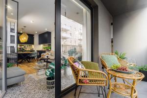 a living room with chairs and a table and a dining room at Lumina I Premium 3-room Apartments with Parking I Balcony I Manufaktura in Łódź