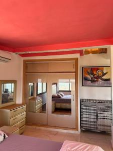 a bedroom with a bed and a large mirror at LOFT Avec une vue paradisiaque in Imouzzer Kandar