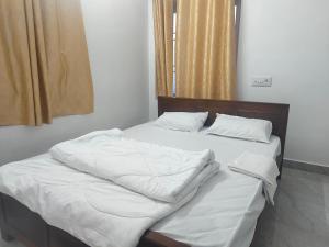 Postel nebo postele na pokoji v ubytování Keerthi Residency