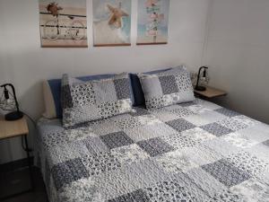 a bedroom with a bed with a checkered blanket at La Nasita in Caleta de Sebo
