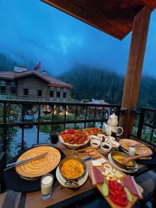 a table filled with plates of food on a balcony at Ayder Altıparmak Suit in Ayder Yaylasi