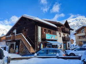 a log building with a car parked in front of it at Appartamenti Anna in Livigno
