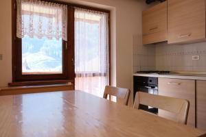 カナツェーイにあるApartments Annyのテーブルと椅子と窓のあるキッチン
