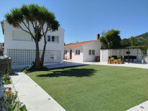 a white house with a palm tree in the yard at La de Simón in A Guarda
