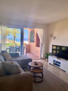 ein Wohnzimmer mit Couch und Flachbildfernseher in der Unterkunft Los Granados de la Duquesa in San Luis de Sabinillas