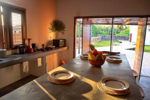 a kitchen with a table with a bowl of fruit on it at Villa Caju Atins in Barreirinhas +11 photos