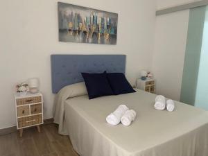 a bedroom with a bed with two pairs of towels on it at C-MAyOR 2 personas in Alcalá de Henares