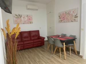a living room with a red couch and a table at C-MAyOR 2 personas in Alcalá de Henares