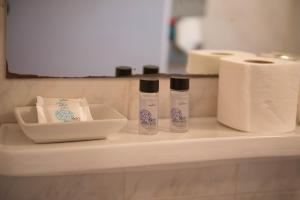 a shelf with toilet paper and two bottles on it at Orsiida sea view apartment Agria in Agria