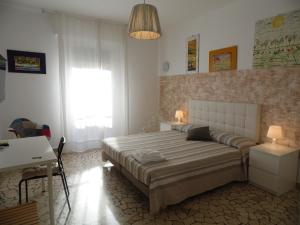 a bedroom with a bed and a desk and a window at Casa Piazza del Santo in Padova