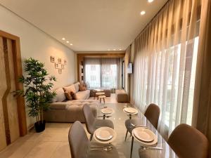a living room with a couch and tables and chairs at Seaside Apartments in Martil +65 photos