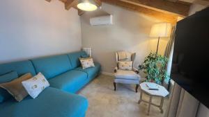 a living room with a blue couch and a chair at Lakeview Jonny house on the roofs in Lezzeno +38 photos