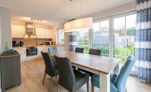 una cucina e una sala da pranzo con tavolo e sedie in legno di Seelöwe a Zingst