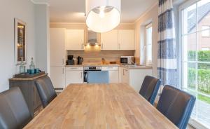 una cucina con tavolo e sedie in legno, un tavolo e una sala da pranzo di Seelöwe a Zingst