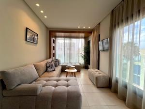 a living room with a couch and a large window at Seaside Apartments in Martil