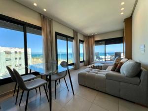 a living room with a couch and a table and chairs at Seaside Apartments in Martil