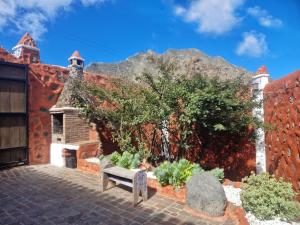 a garden with a bench in front of a building at CHC - Casa Rural del Ciruelo in Buenavista del Norte