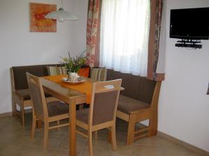 a dining room table with chairs and a television at Apartment Galtenberg in Alpbach