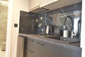 a kitchen with black marble counter tops and a sink at Feel Athens Studios at Monastiraki in Athens +37 photos