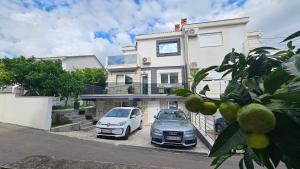 two cars parked in front of a house at Villa Montemaris Budva in Budva