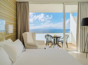 a hotel room with a bed and a view of the ocean at H10 Gran Tinerfe - Adults Only in Adeje