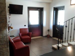 a living room with two chairs and a television at AgriHotel Papaya in San Pietro Apostolo