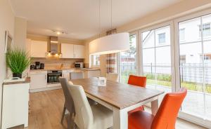 a kitchen and dining room with a wooden table and chairs at Seeteufel in Zingst
