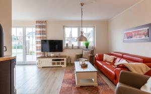 a living room with a red couch and a tv at Seeteufel in Zingst