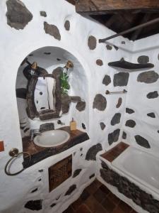 a bathroom with a sink and a rock wall at CHC - Casa Rural del Molino in Buenavista del Norte
