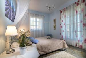 a bedroom with a bed and a table with a lamp at Greek House Hotel in Neos Marmaras