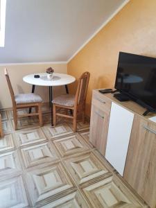 a kitchen with a table and a tv and a table and chairs at Small cute single room A2 in Pancevo in Pančevo