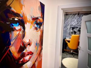 a painting of a woman is hanging on a wall at Stay in Skopje - Prime Location Apartment in Skopje +29 photos