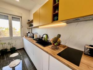 a kitchen with white cabinets and a counter top at Stay in Skopje - Prime Location Apartment in Skopje