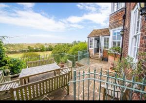 a patio with two benches and a table on a house at Benson House - Rye Town Centre, East Sussex in Rye