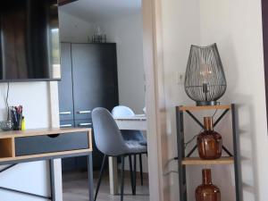 eine Küche mit einem Tisch, einem Stuhl und einer Lampe in der Unterkunft Holzhaus am Listersee in Windebruch + 30 Fotos