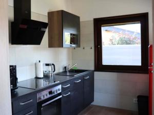 eine kleine Küche mit Spüle und Fenster in der Unterkunft Holzhaus am Listersee in Windebruch