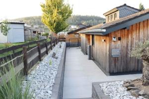 ein Gehweg in einem Hof neben einem Holzgebäude in der Unterkunft Holzhaus am Listersee in Windebruch