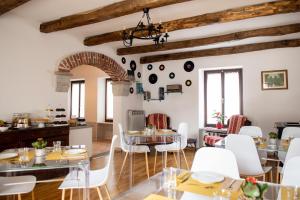 a dining room with white chairs and tables at Agriturismo Ca' del Clat in Bagnolo Piemonte