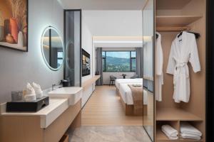 un bagno con lavandino e specchio di 隽雅酒店芙蓉镇景区点 a Wang-ts'un