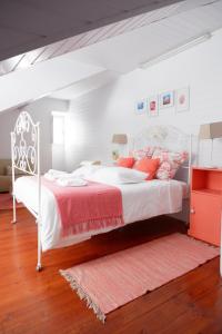 a bedroom with a white bed with red pillows at Casa do Vale das Furnas in Furnas
