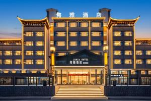 un grande edificio con un cartello che legge il nuovo hotel imperiale di 隽雅酒店芙蓉镇景区点 a Wang-ts'un