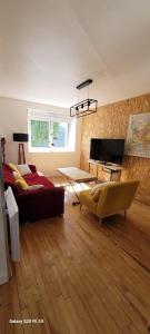 a living room with a couch and a table and a television at maison cosy in Quimper