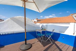 a patio with a table and an umbrella on a deck at Host Wise - Elegant Loft with Historic Charm & Terrace in Portel