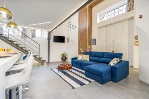 a living room with a blue couch and stairs at Host Wise - Elegant Loft with Historic Charm & Terrace in Portel