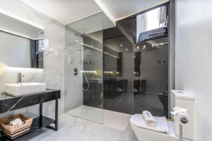 a bathroom with a shower and a toilet and a sink at Host Wise - Elegant Loft with Historic Charm & Terrace in Portel +26 photos