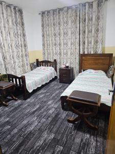 a bedroom with two beds and a table and chairs at Travelers Rest in Wadi Musa