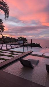 a pool of water with a sunset in the background at Silk Cotton Cottages in Parrot Hall