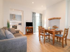 a living room with a couch and a table with chairs at Alfreton Cottage in Alfreton
