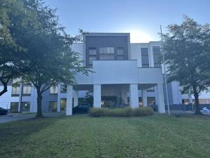 a large white building with trees in front of it at Homewood Suites by Hilton Tulsa South Medical District in Tulsa
