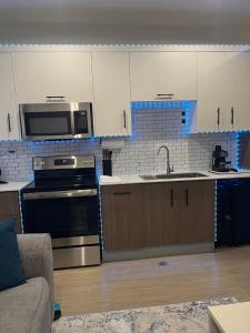a kitchen with stainless steel appliances and white cabinets at Skyloft Luxora Apts in Port-of-Spain